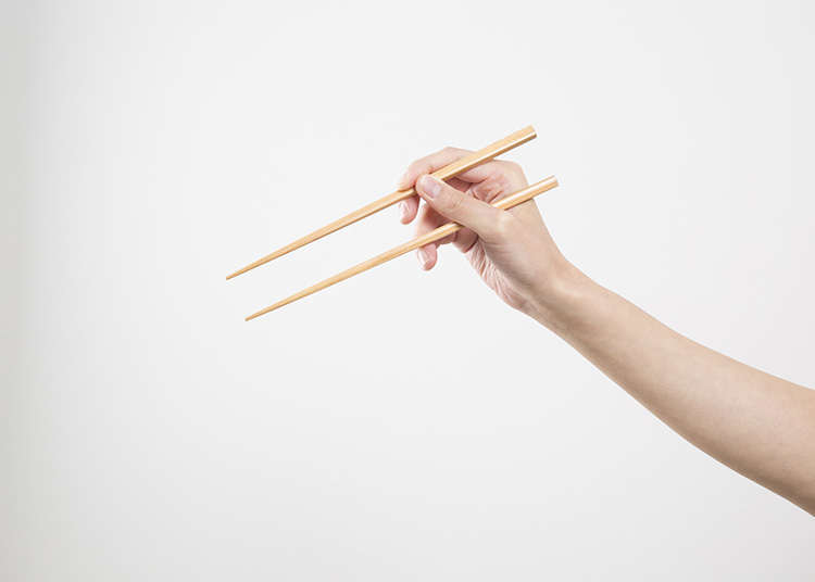 先用右手拿一支筷子,之后用大姆指,食指和中指像拿笔一样挟住筷子